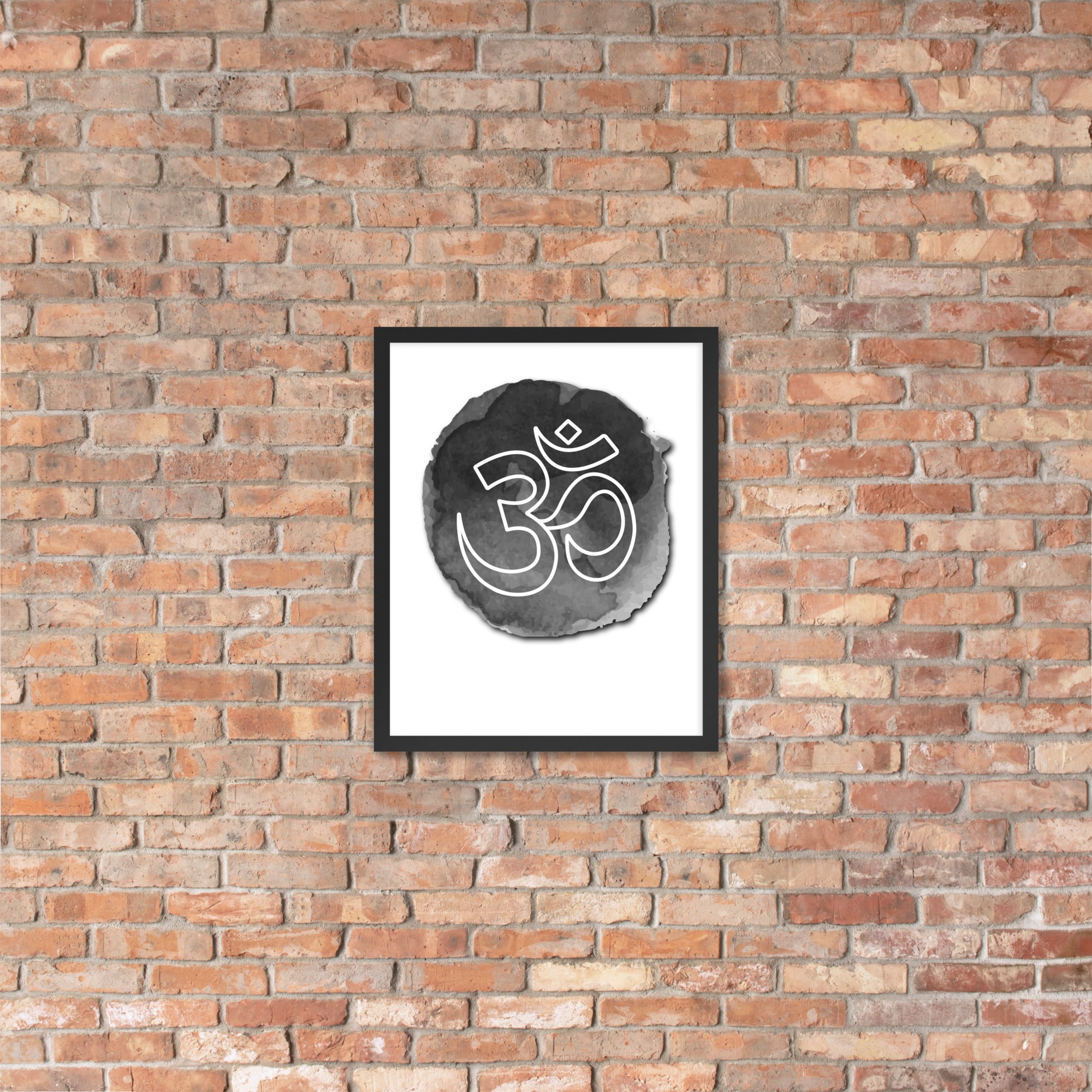 Framed artwork with Om symbol on a brick wall